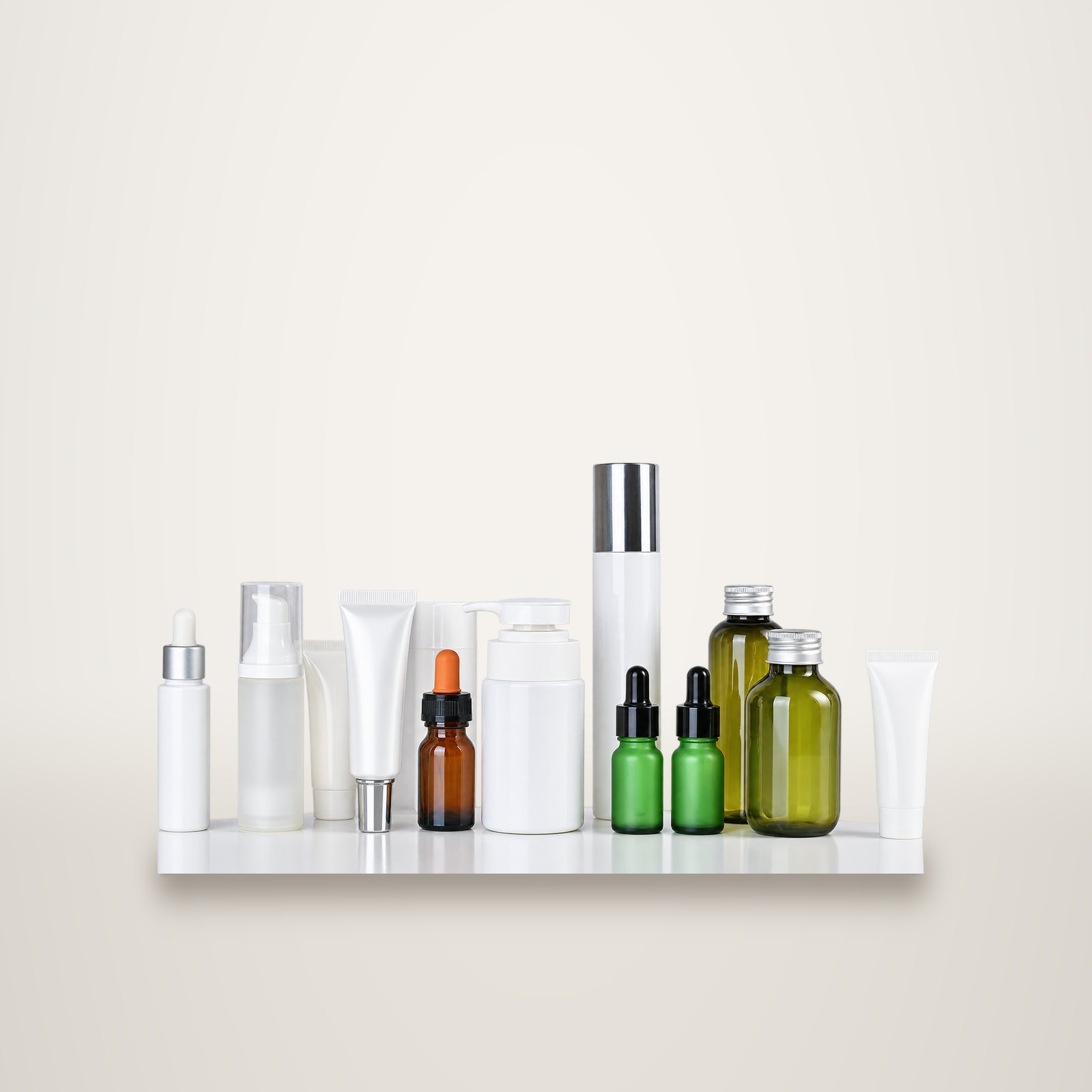Flacons, tubes et pipettes de produits de soin alignés sur une étagère.